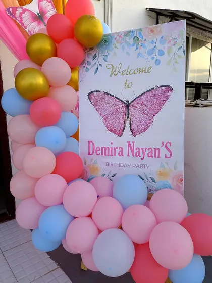 This butterfly-themed welcome board uses a beautiful mix of pastel balloons in pink, blue, and gold to create a soft and dreamy entrance.