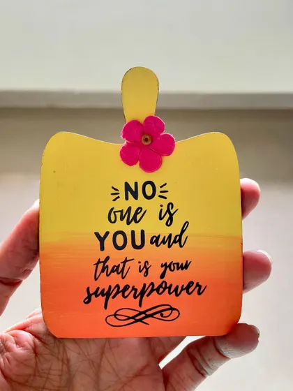 "No one is you and that is your superpower." A small, chopping-board shaped hanging with a powerful message.