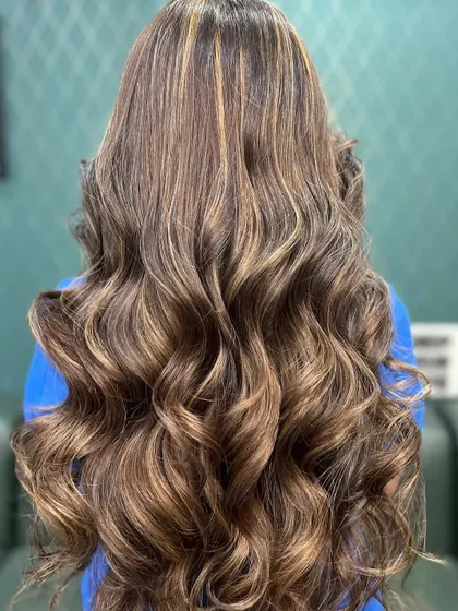 Long, flowing waves with expertly blended caramel brown highlights. This look is elegant and brilliant, perfect for any season.