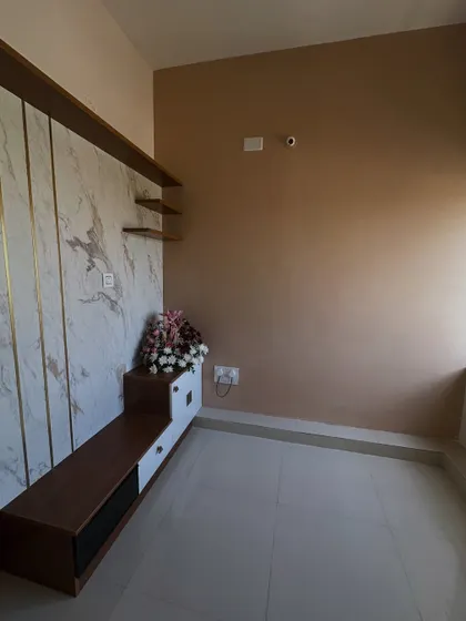 A full view of a living room project from different angles. We painted the walls in a neutral beige that pairs well with the white and wood entertainment unit, creating a warm and modern feel.