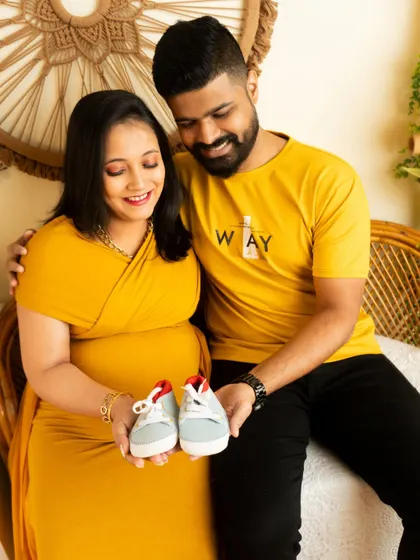 A sweet and simple pose with the couple holding up a pair of baby shoes. It's a classic way to announce you're expecting.