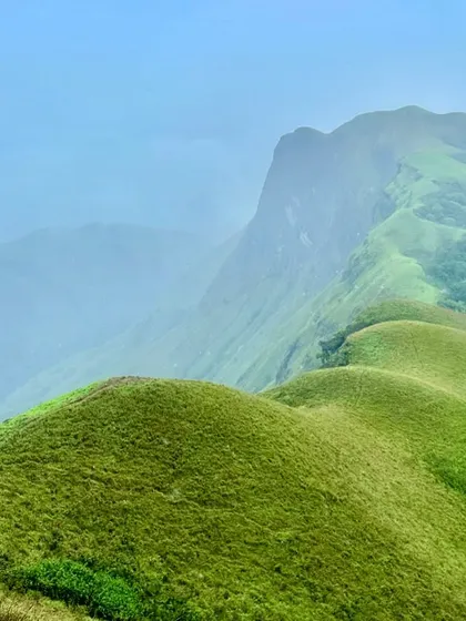 The iconic "horse face" range of Kudremukh, with its unique rolling green hills. A must-do trek for any serious hiker in Karnataka.