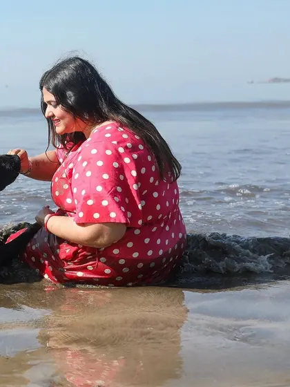 A shared moment of peace and connection amidst the gentle waves. This photograph captures the quiet bond between Rucha and her black Labrador, Murphy, during one of our 'joy of splashes' beach sessions.
