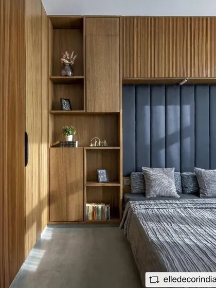 The guest room features a comfortable Murphy bed flanked by custom wooden cabinetry with integrated shelving and fluted panel details, maximizing both style and function.