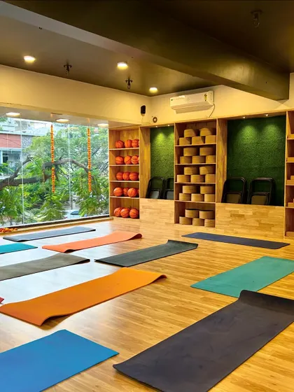 Our studio is prepared for a class, with mats arranged to give everyone personal space. The clean wooden floors and organized prop shelves reflect our commitment to a quality experience.