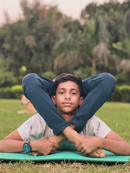 This lying-down contortion pose brings the legs behind the head, showcasing amazing hip and spine flexibility. Try it.