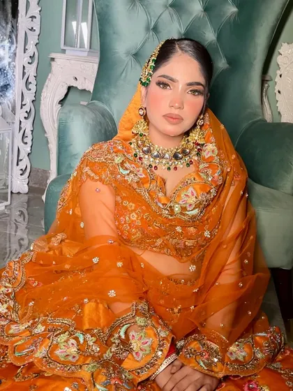 The rich orange of the lehenga is the star here, and the makeup is designed to complement it perfectly. The warm tones on the skin and eyes create a cohesive, sun-kissed look.