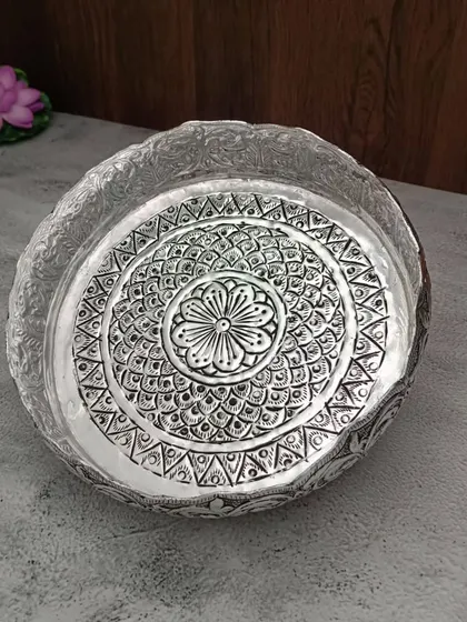 A top view of another antique German silver urli, this one with a beautiful mandala-like design in the center.