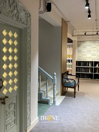A quiet corner in my Whitefield showroom, featuring an ornate door and a classic armchair. This image captures the blend of traditional craftsmanship and modern design that defines the Trove experience.