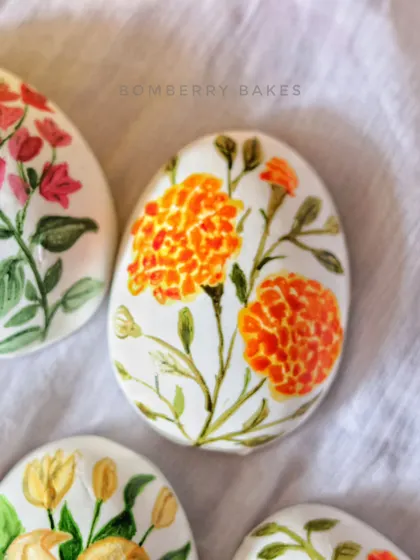 A vibrant marigold design hand-painted onto an edible marzipan Easter egg.