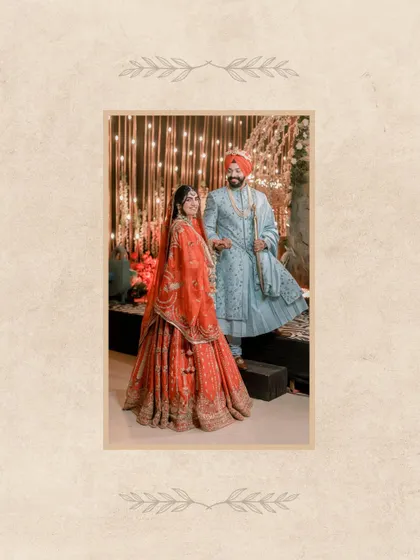A full-length portrait of Vanaja and Angad, framed to highlight the elegance of their attire and the beautiful decor.