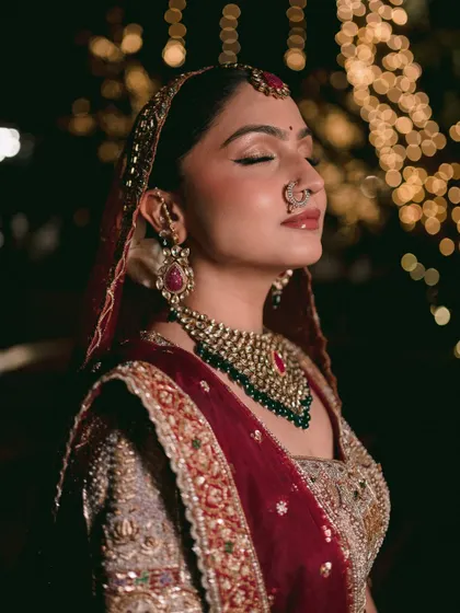 A bridal portrait is more than just a photo of the bride; it's about capturing her essence right before she begins her new chapter. This close-up, with the soft focus and bokeh lights, highlights the serene, dreamlike quality of the moment. It’s an artistic shot that focuses on emotion and beauty.