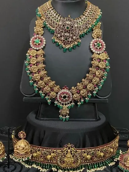 Another view of our green and red kemp bridal set. You can see the detailed craftsmanship in the choker, long necklace, and the accompanying accessories, all available for rent.