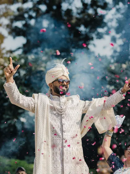 The groom's jubilant entrance, celebrating with friends and a shower of petals. We capture the energy and excitement of the Baraat.
