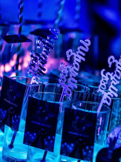 Even the smallest details contribute to the theme. Custom drink stirrers and personalized glass tags, all glowing under the blue ambient light, ensure a cohesive and immersive experience for every guest.