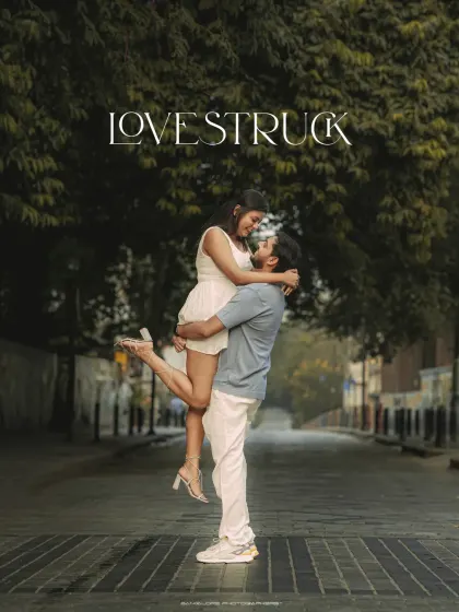 A fun and energetic "Love Struck" pre-wedding photo. The groom lifting the bride in the middle of a street is a moment of pure, spontaneous joy.