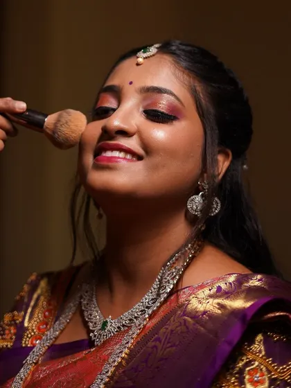 A behind-the-scenes moment, applying the finishing touches. That final dusting of powder sets the makeup and ensures a long-lasting, flawless glow.