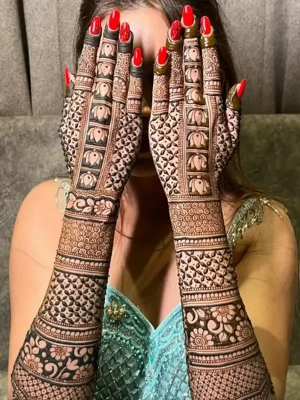 A full bridal design is a statement. This intricate pattern, featuring traditional elephant motifs, covers the hands and arms in a stunning display of detailed henna art.