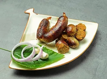 Our handmade Thai Sai Oua pork sausages, beautifully plated and ready to eat. These are packed with the fresh flavors of Thai galangal, lemongrass, and kaffir lime, offering a zesty and aromatic experience.