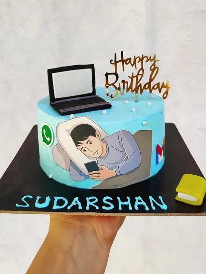 A humorous cake for someone addicted to their phone and laptop. The edible image shows them in bed, scrolling away.