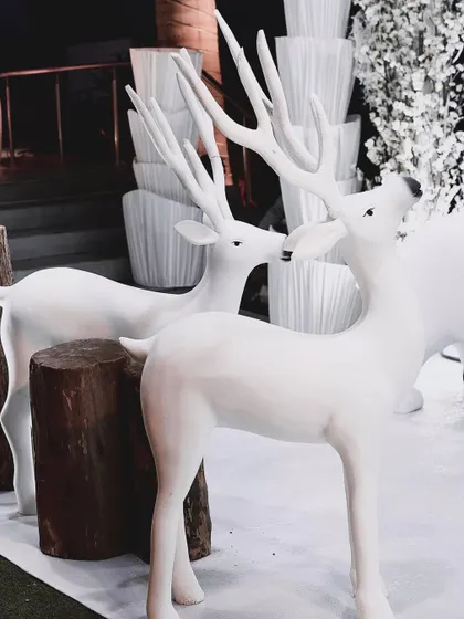 A pair of majestic white reindeer stand guard at the entrance to the winter wonderland. These life-sized props were key elements in creating an immersive and photo-worthy experience.