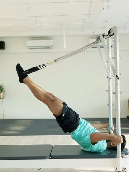 Our expert coach demonstrates a challenging inversion on the reformer tower. This move builds upper body strength and decompresses the spine.