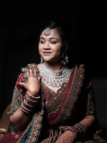 A beautiful portrait of the bride, showcasing her stunning diamond and ruby necklace and detailed henna.