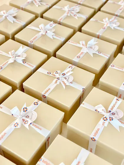 A sea of elegantly prepared corporate gift boxes ready for the next step. For this BDI Plus order, we used neutral-toned boxes with custom-branded ribbons, creating a clean and professional look suitable for any corporate occasion.