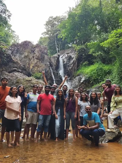 The whole team gathered for a photo in front of a waterfall. These shared experiences in nature are what make my offsites so effective.