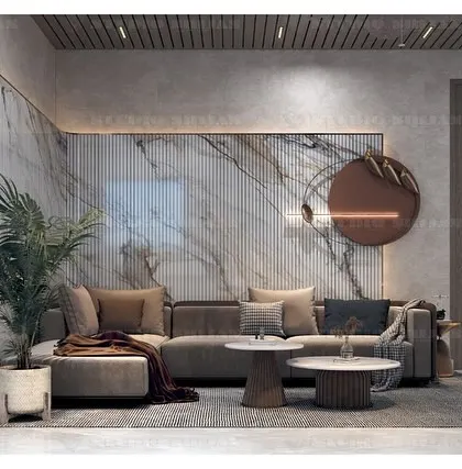 A lobby in Kirti Nagar, New Delhi, designed with a warm, earthy color palette. A large, comfortable sofa is set against a wall of fluted panels and textured marble.