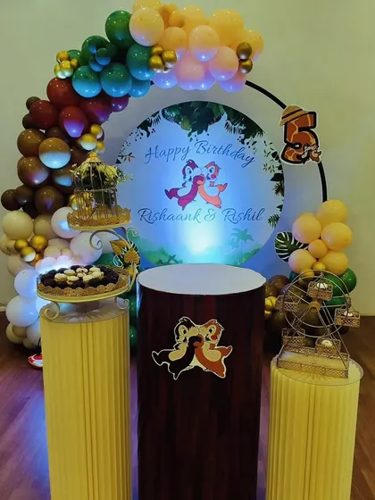 A charming Chip 'n' Dale theme for a 5th birthday. The decor features a balloon arch in earthy tones, a custom backdrop with the characters, and themed pedestals for desserts.