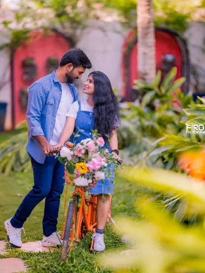 A romantic gaze between a couple with a flower-filled bicycle. The soft, natural light and the garden setting create a beautiful, dreamy atmosphere.
