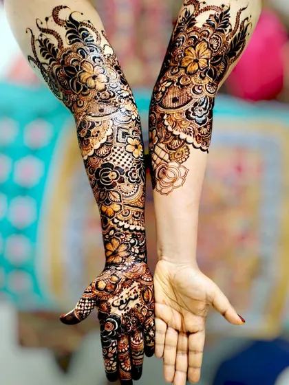 A work in progress, showing one arm fully completed with an intricate bridal design.