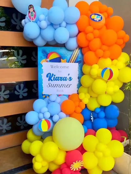 A custom "Welcome to Kiara's Summer Bash" sign at the entrance, decorated with colorful balloons to set the party mood.