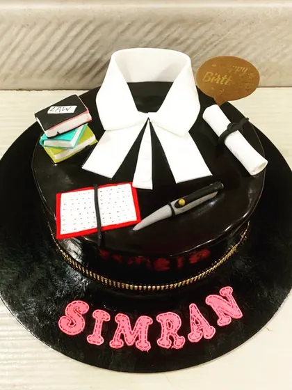 A sleek and professional cake for a lawyer. This all-black cake is topped with a fondant advocate's band, law books, and a graduation scroll.