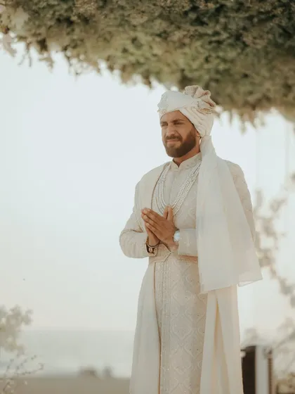 The groom, looking serene and happy, waiting for his bride at the mandap. A moment of calm before the celebrations.