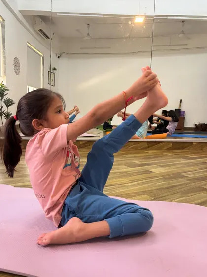 This young student is mastering the Krounchasana, or Heron Pose, which requires significant hamstring flexibility.