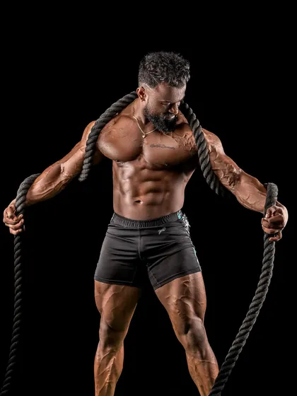 Holding the battle ropes, ready for a high-intensity workout. This kind of training is key for achieving the shredded look.