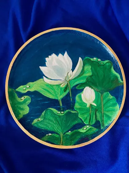 The white lotus plate photographed against a rich blue fabric, enhancing the colors of the water and the purity of the flower.