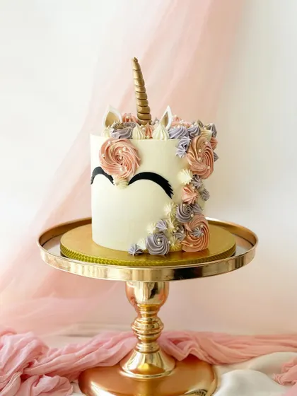 An elegant and minimalist unicorn cake. I used buttercream piping in muted tones to create a floral mane, with the horn and ears completing the abstract design.