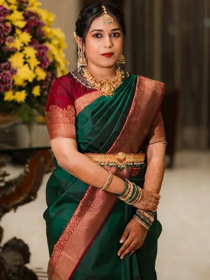 A bridesmaid looking stunning in a traditional green silk saree. I created a classic South Indian look with a bold red lip, gold jewelry, and a neat, braided hairstyle.