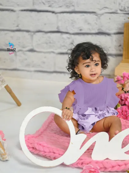 A wide shot of the pink and purple first birthday setup.