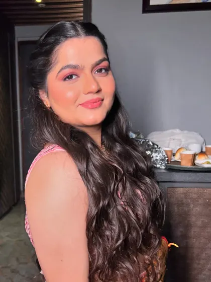 My bride Ishita's Sangeet look, featuring bold pink eyeshadow and soft, romantic curls.