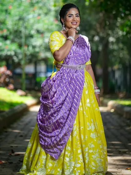 The vibrant yellow and contrasting purple dupatta make this a standout festive outfit.