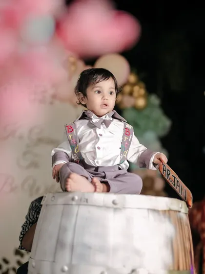 A regal pose from the birthday boy. Sitting atop a barrel, he looks like the king of his circus-themed birthday celebration.