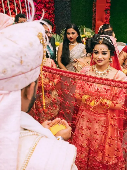 The bride looks at the groom through her veil during the wedding ceremony, a moment filled with anticipation.