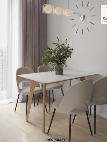 The minimalist dining set with slim-legged chairs and a simple table complements the clean aesthetic of the adjoining kitchen.