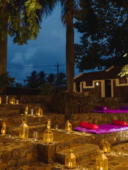 The venue's stone steps are transformed into a romantic seating area with purple cushions and dozens of glowing lanterns, creating a magical ambiance for the Sangeet night.