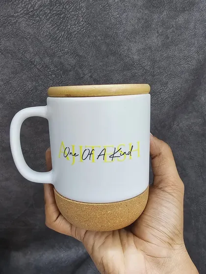 Here is the white ceramic mug with a cork base, customized with the phrase 'One Of A Kind'. The wooden lid provides a beautiful contrast and can also be engraved.