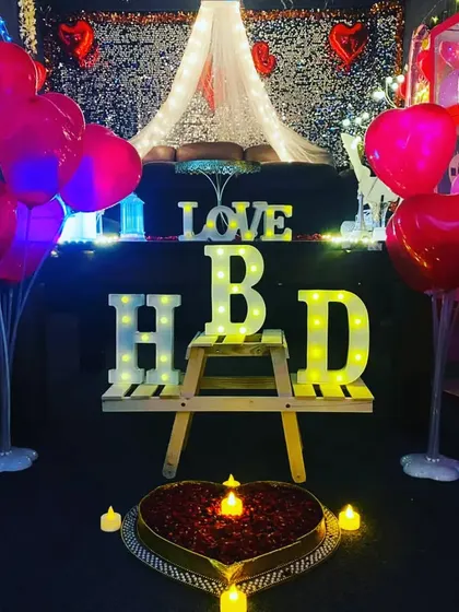 A close-up of our romantic birthday decor. The heart-shaped cake, 'HBD' letters, and 'LOVE' sign create a perfect setting for a couple's celebration.